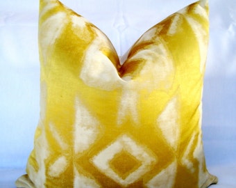 May include: A yellow and white patterned throw pillow with a geometric design. The pillow is made of a soft, luxurious fabric.