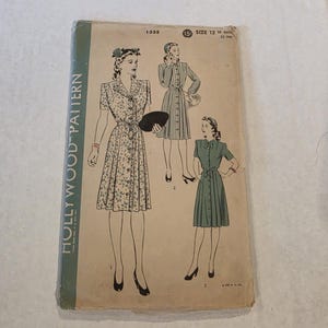 May include: Vintage Hollywood Pattern 1335, size 12, featuring illustrations of three button-down dresses. The cover is aged with a green border and the words "HOLLYWOOD PATTERN" printed vertically. The dresses are in different styles.