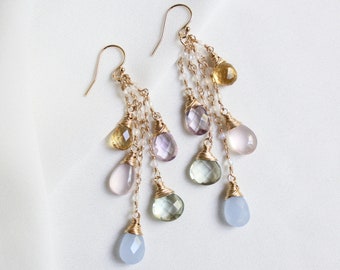 Könnte beinhalten: Goldene Ohrringe mit einer Kaskade aus pastellfarbenen Edelsteintropfen, darunter Amethyst, grüner Aventurin, Chalcedon und Citrin.