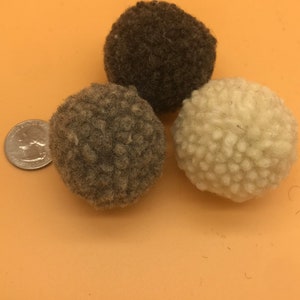 Bouncy Felted Wool Cat Balls. This image shows 3 small wool balls. Displayed next to a quarter, showing the balls are about twice the size of a quarter - Great to carry and bat all over the house - Washable plastic free toys with textures cats love