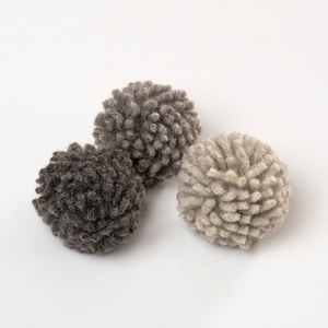 May include: A set of three ceramic nesting bowls in graduating sizes. The bowls are white with a speckled, textured finish and a slightly flared rim. The largest bowl measures approximately 8 inches in diameter.