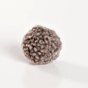 This image shows single small felted wool ball. A fuzzy naturally colored pom pom the size of a ping pong. Great to carry and bat all over the house - Washable plastic free toys with textures cats love.