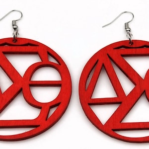May include: A pair of red wooden earrings with geometric cutouts. The earrings are round and have a silver hook.