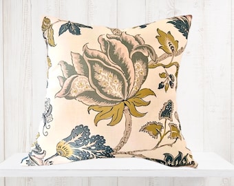 May include: A decorative throw pillow with a floral pattern in shades of pink, green, yellow, and blue on a cream background.
