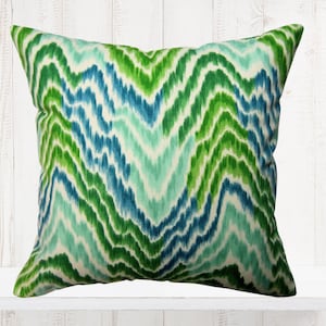 May include: A green and blue patterned throw pillow with a wavy design.