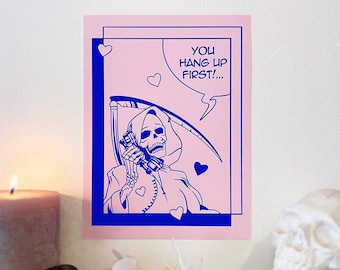 May include: A pink card with a blue border features a cartoon image of the Grim Reaper on the phone. The Grim Reaper is wearing a blue hooded robe and holding a blue scythe. The card has the text "You hang up first!" in blue.