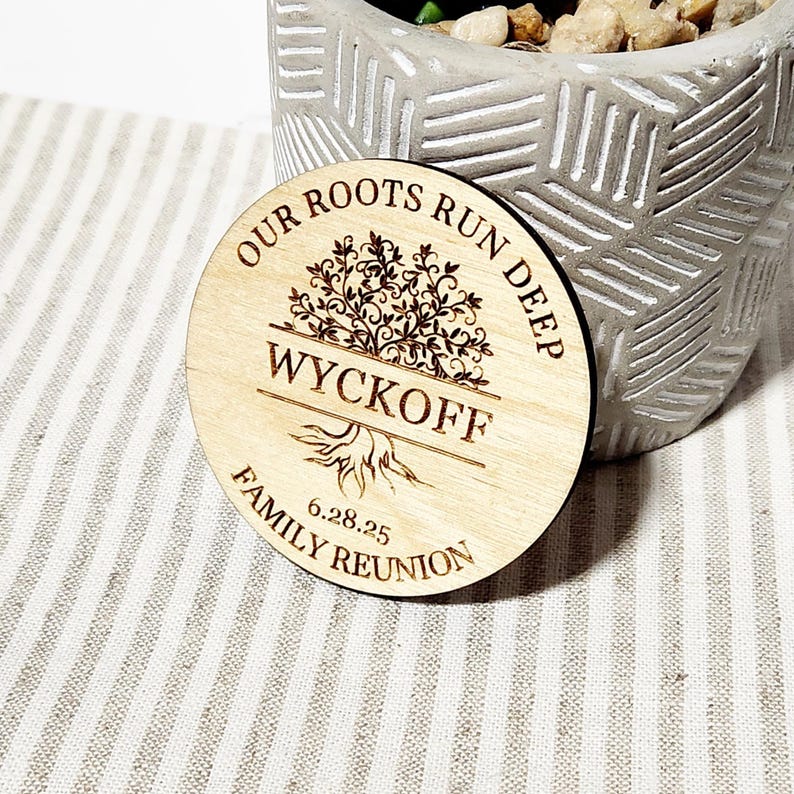May include: A round wooden sign with the text "Our Roots Run Deep" and a tree design. The sign also includes the name "Wyckoff" and the date "6.28.25". The text "Family Reunion" is at the bottom of the sign.