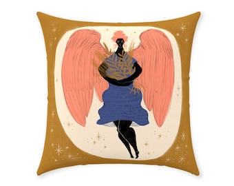 May include: Square decorative pillow featuring an illustration of an angel with coral wings and a blue dress. The angel holds a bundle of golden leaves. The pillow has a mustard-colored border with star accents and a cream-colored background.