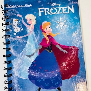 May include: A spiral-bound notebook featuring a blue cover with Disney Frozen characters Elsa, Anna, and Olaf. The cover displays the text A Little Golden Book and Disney FROZEN, surrounded by white snowflake illustrations on a gradient blue background.