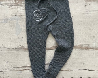 Pode incluir: Calças de bebé de malha cinzenta com cintura de cordão. As calças têm uma pequena etiqueta branca com o texto "Little French Knits" nelas.