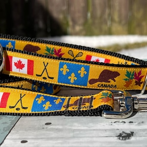 Peut inclure: Un collier et une laisse pour chien jaune et noir sur le thème canadien. Le collier et la laisse présentent des images du drapeau canadien, d'un castor, de feuilles d'érable, de bâtons de hockey et de bâtons de crosse. Le texte "CANADA" est imprimé sur la laisse.