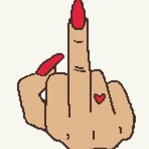 Puede incluir: Una mano con esmalte de uñas rojo haciendo el dedo medio. La mano tiene un pequeño tatuaje de corazón rojo en el dedo anular.