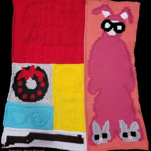 May include: A colorful crocheted blanket with a red, yellow, blue, and white patchwork design. The blanket features a pink crocheted bunny with a black mask and a red bow. The text "Tested by Marie Beland" is at the bottom of the blanket.