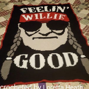 Puede incluir: Manta de crochet con fondo negro y texto blanco que dice "Feelin' Willie Good". La manta presenta una imagen de crochet blanca y gris de Willie Nelson con un pañuelo rojo y gafas de sol.
