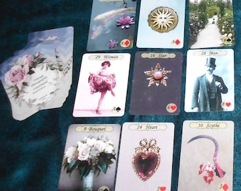 May include: A collection of vintage-style playing cards featuring various illustrations. The cards depict images such as a woman, a bouquet of flowers, a heart-shaped jewel, and a man in a top hat. The cards have a vintage photographic aesthetic.