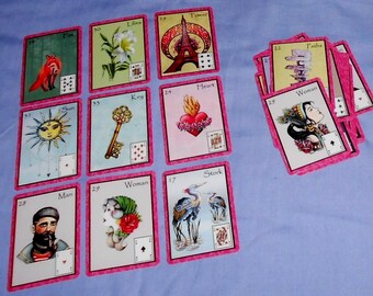 Puede incluir: Un despliegue de cartas de tarot con bordes rosas, que muestran imágenes de un zorro, lirios, una torre, caminos, un sol, una llave, un corazón, una mujer, un hombre, una cigüeña y una mujer con una rosa. Las cartas están dispuestas en una cuadrícula sobre una superficie azul.
