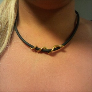 May include: A black choker necklace with a gold snake design.