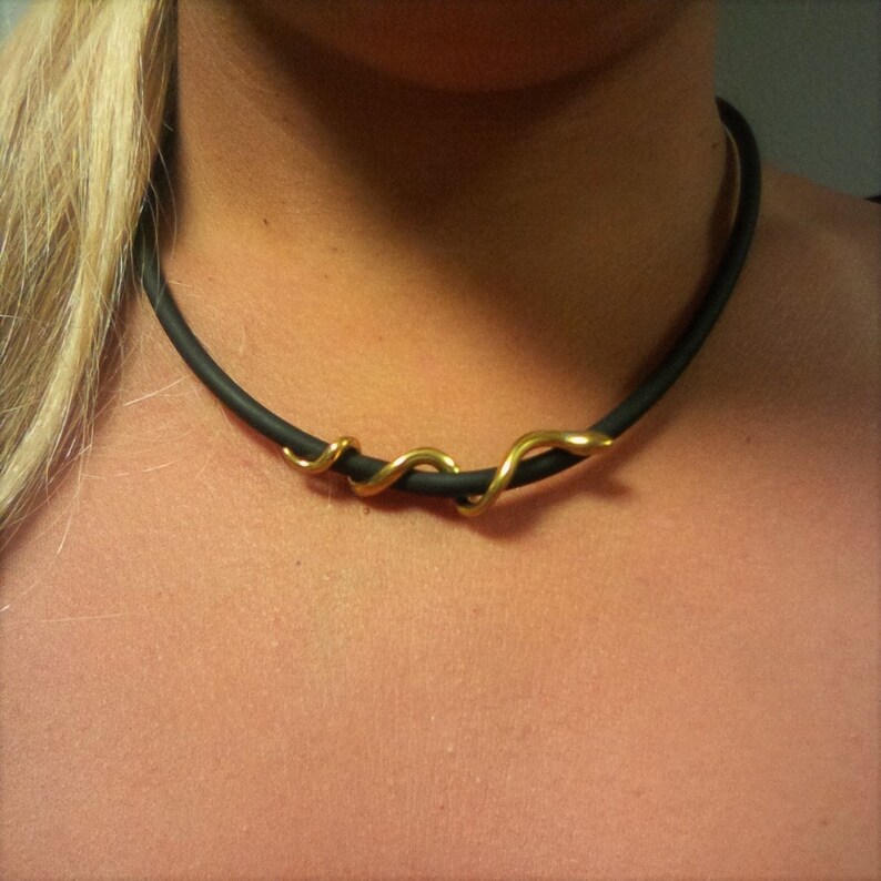 May include: A black choker necklace with a gold snake design.