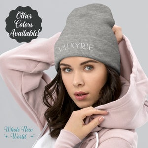 May include: A gray beanie with the word "VALKYRIE" embroidered in white. The beanie is ribbed and has a folded cuff. The image also includes the text "Other Colors Available!" and "Whole New World".