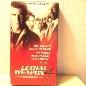 May include: A VHS tape for the movie Lethal Weapon 4, featuring Mel Gibson, Danny Glover, Joe Pesci, Rene Russo, Chris Rock, and Jet Li. The text on the cover reads "The gang's all here." and "A Richard Donner Film."
