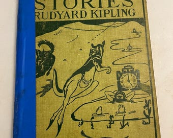 May include: A vintage book titled "Just So Stories" by Rudyard Kipling. The cover is a light green with black illustrations and text, and a blue spine. The illustrations depict stylized animals and figures.