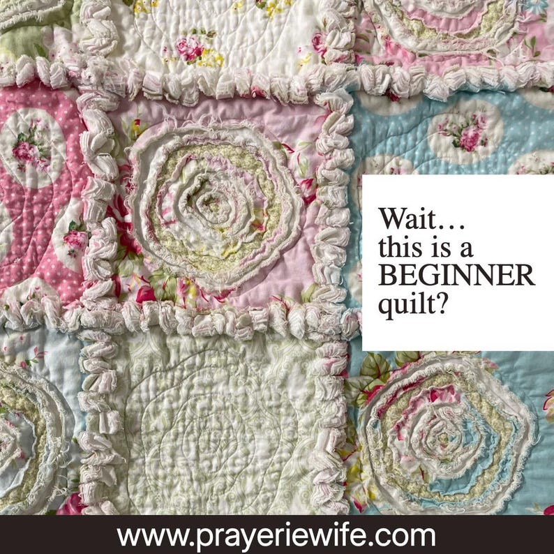 May include: A handmade quilt with a patchwork design. The quilt features squares in shades of pink, blue, and white, adorned with floral patterns and ruffled edges. The text "Wait... this is a BEGINNER quilt?" is visible.