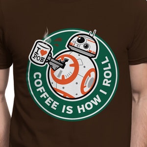 May include: Brown t-shirt with a green circle graphic featuring a Star Wars BB-8 droid holding a coffee cup with the text "I love Poe" on it. The text around the droid reads "Coffee is how I roll."