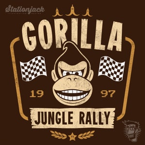 May include: A vintage-style graphic with a distressed brown background featuring a cartoon gorilla with a toothy grin. The text "GORILLA" is above the gorilla, and "JUNGLE RALLY" is below. The text "19" and "97" are on either side of the gorilla. There are three yellow bananas at the top of the graphic.