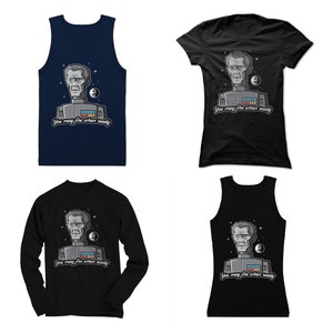 May include: Four different t-shirts featuring a cartoon image of a man with the text "You may fire when ready". The shirts are available in black, navy blue, and white.