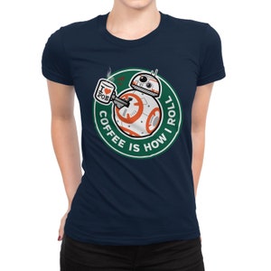 May include: A navy blue t-shirt with a green circle graphic featuring a droid character holding a coffee cup with the text "I love Poe" on it. The text around the droid reads "Coffee is how I roll."