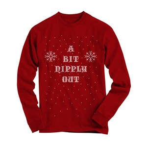 May include: Red long-sleeve shirt with a white snowflake pattern and the text "A Bit Pipply Out" in a pixelated font.