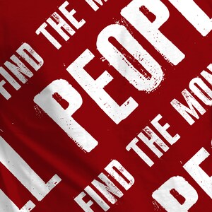 May include: Red t-shirt with white text that reads "Find the People Find the Moment Be the People".