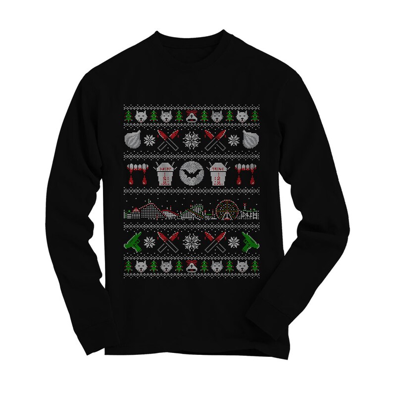Puede incluir: Su&eacute;ter negro de manga larga con un dise&ntilde;o navide&ntilde;o que incluye un murci&eacute;lago, gotas de sangre, cuchillos y una monta&ntilde;a rusa. El dise&ntilde;o est&aacute; en estilo pixelado.