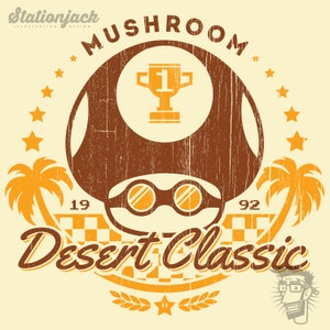 May include: A vintage-style graphic featuring a brown mushroom with racing goggles and a trophy. The design includes palm trees, stars, and the text "Mushroom Desert Classic 1992" in a distressed font, all on a cream background.