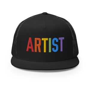 May include: Black trucker hat with a rainbow embroidered "ARTIST" on the front.