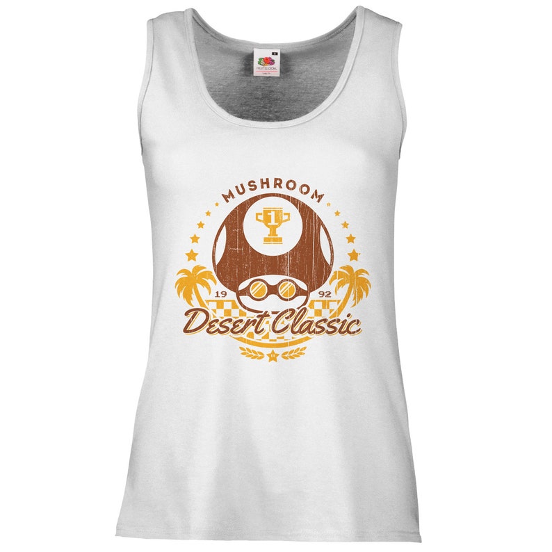 May include: White tank top with a distressed graphic featuring a brown mushroom with sunglasses, a trophy, palm trees, and the text "Mushroom Desert Classic 1992". The design is in shades of brown and gold.