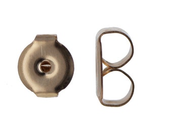 May include: Two gold-toned earring backs, one is a round disc with a small hole in the center, the other is a curved, open-backed design.