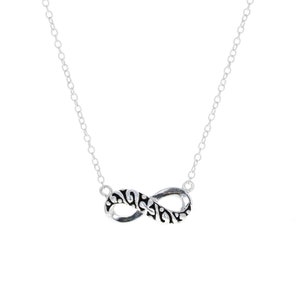 May include: A silver infinity necklace with a black filigree design. The necklace is on a white background.