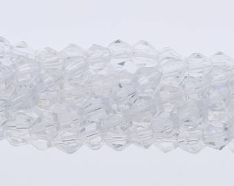 May include: A strand of clear glass beads with a faceted, diamond-like shape. The beads are strung together to create a long, continuous strand.