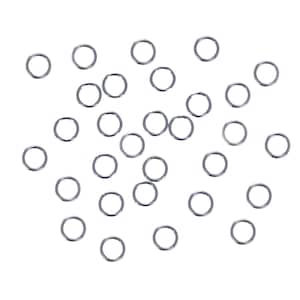 May include: A collection of small, silver-colored jump rings scattered against a white background. These open rings are circular and appear to be made of metal. They are commonly used in jewelry making and crafting.