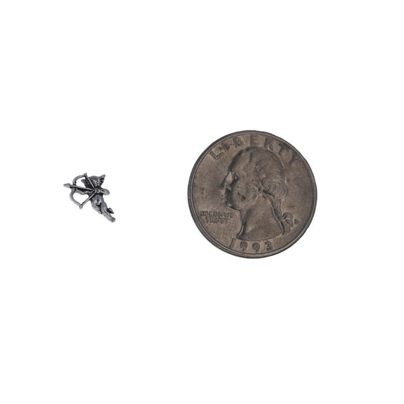 May include: A silver charm in the shape of a cupid with a bow and arrow. The charm is about the size of a UK 20 pence coin.