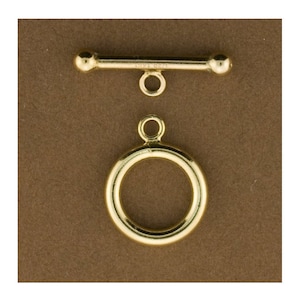 May include: Gold-toned metal toggle clasp with a round ring and a straight bar with rounded ends.