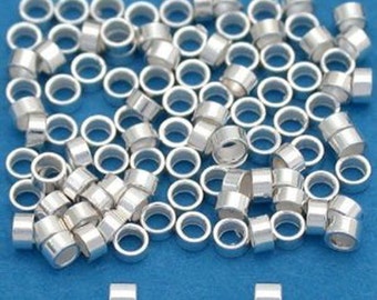 May include: A large pile of silver jump rings, perfect for jewelry making. The rings are all the same size and are arranged in a random pattern. There are two small silver squares in the bottom of the image.