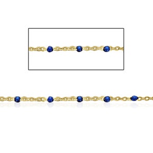 May include: A gold chain necklace with small blue beads. The chain is delicate and the beads are evenly spaced.