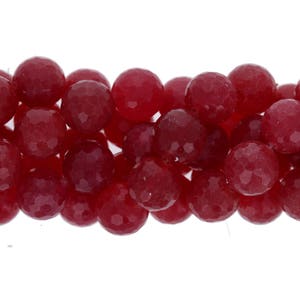 May include: A strand of red faceted gemstone beads. The beads are round and have a smooth, polished finish.