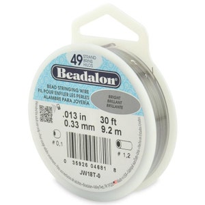 May include: A spool of 49 strand Beadalon bead stringing wire in bright silver. The wire is 0.33 mm thick and 9.2 metres long. The label also includes the measurements in inches and feet.