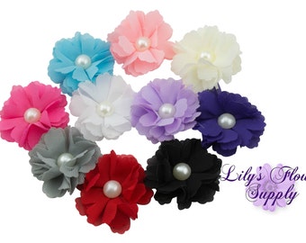 May include: Assortment of ten small fabric flowers with pearl centers in various colors, including pink, blue, purple, white, gray, and black.