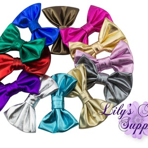 May include: Assortment of metallic bow hair clips in various colours, including gold, silver, red, blue, green, purple, pink, and brown.  Lily's Flower Supply.