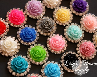 May include: Assortment of 15 colorful rhinestone-embellished flower embellishments. Each flower is a different color, including pink, blue, green, white, yellow, red, and purple. The flowers are surrounded by clear rhinestones.