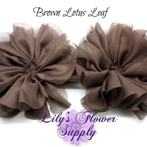 May include: Two brown lotus leaf flower embellishments with a sheer, light brown trim. The text "Brown Lotus Leaf" is at the top, and "Lily's Flower Supply" is at the bottom. These fabric flowers are ideal for crafting and DIY projects.